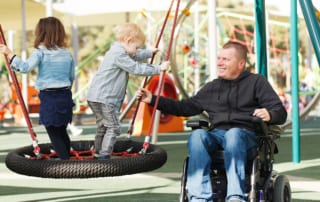 Man in wheel chair at park with child