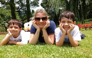 three kids laying on grass smiling