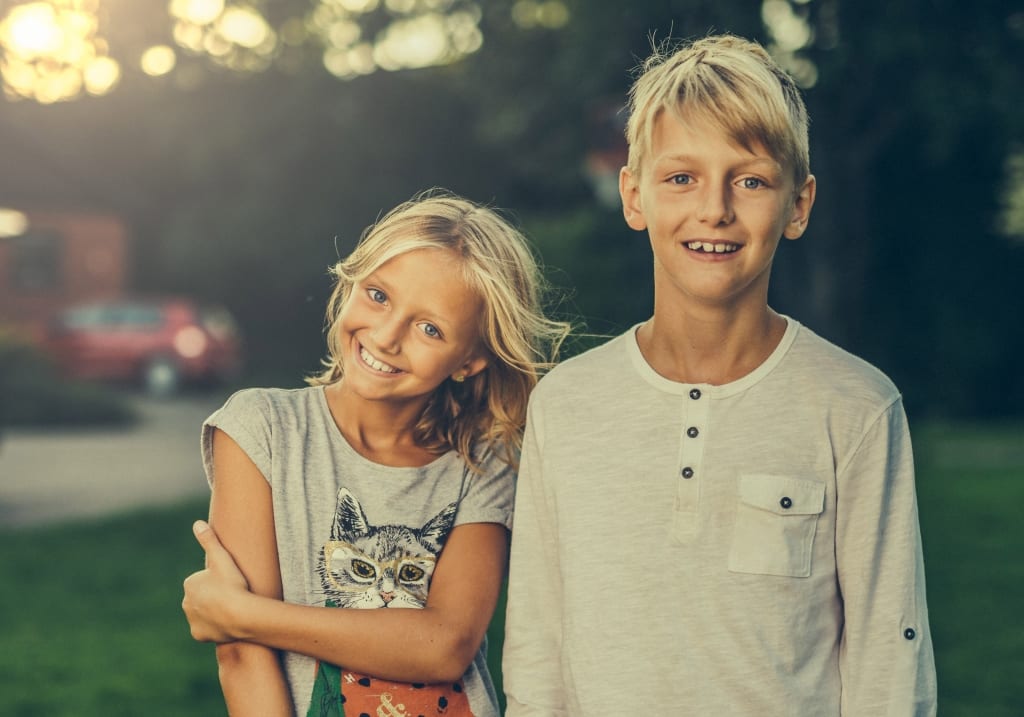 Girl and Boy smiling outside.