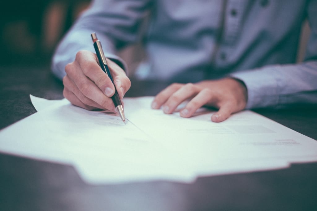 writing with pen on desk