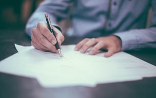 writing with pen on desk