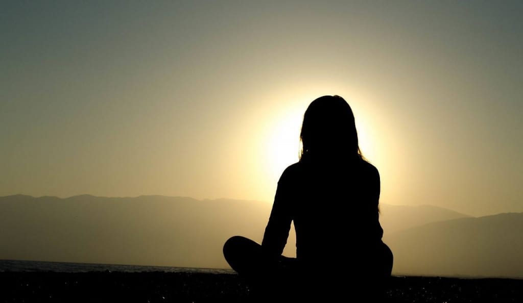 silhouette of woman facing sunrise 